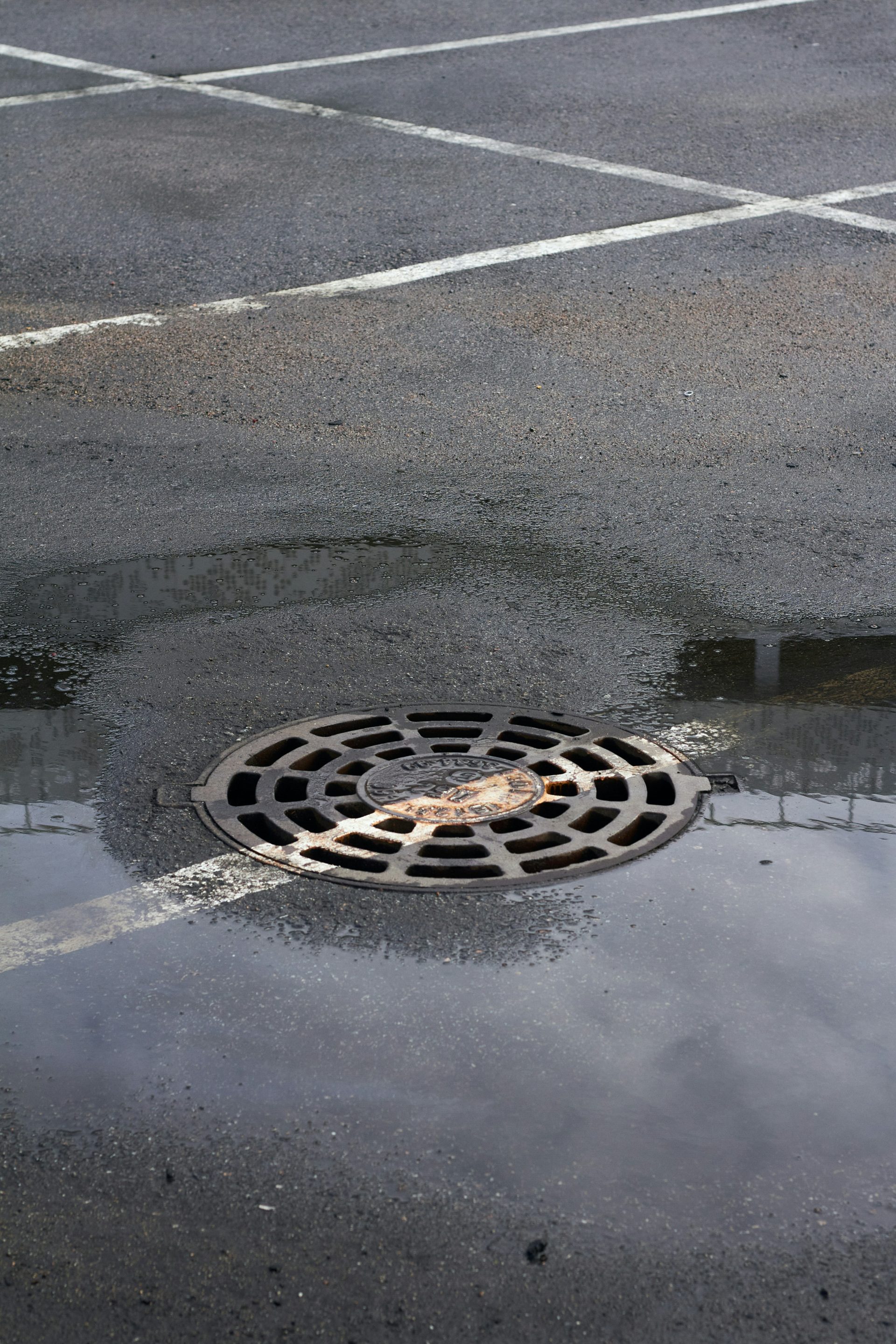 una tapa de alcantarilla en medio de un estacionamiento